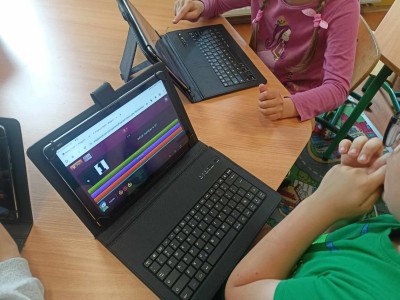 Dzieci rozwiązujące zadania z j. angielskiego przy laptopach